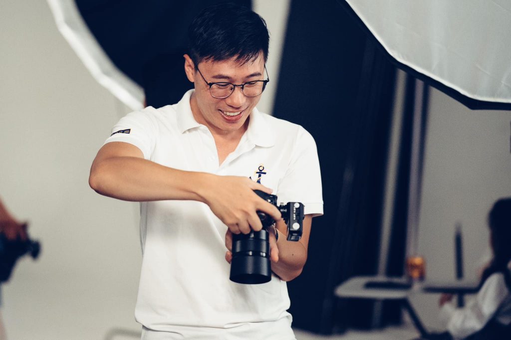 Chân dung Lusman, photographer chuyên chụp chân dung tại TP.HCM, cầm máy ảnh, ánh sáng bên tự nhiên