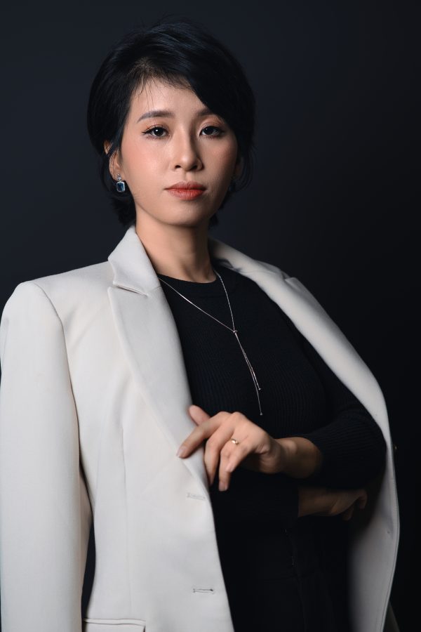 Chụp ảnh chân dung doanh nhân nữ tóc bob ngắn, mặc blazer sáng khoác ngoài áo đen cổ tròn, trên phông nền tối, thực hiện bởi Lus Photo