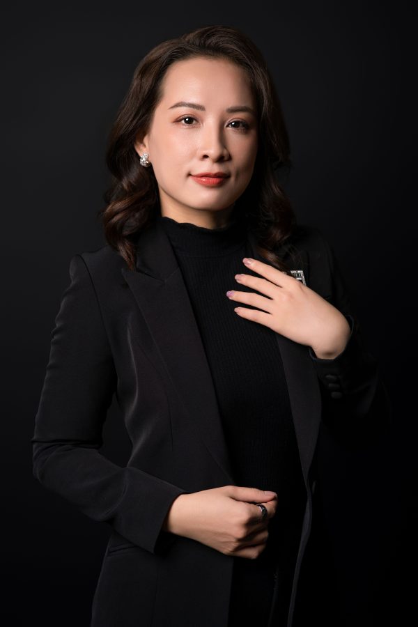 Chụp ảnh chân dung doanh nhân nữ tóc xoăn mặc blazer trắng phối áo cổ lọ đen, trên phông nền đen, thực hiện bởi Lus Photo