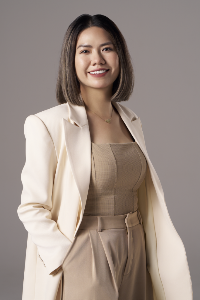 Chân dung doanh nghiệp: nữ founder mặc blazer kem, tóc dài, cười nhẹ, phông kem trơn, thực hiện bởi Lus Photo