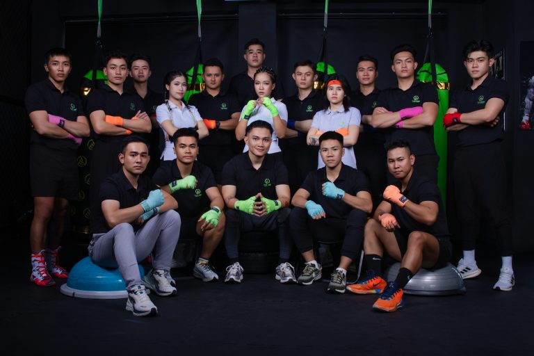 Chụp ảnh phòng tập gym: đội ngũ huấn luyện viên The King ngồi và đứng giữa thiết bị tập cùng dây kháng lực, thực hiện bởi Lus Photo